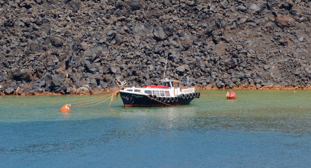 Boat in front of solidified basaltic lava